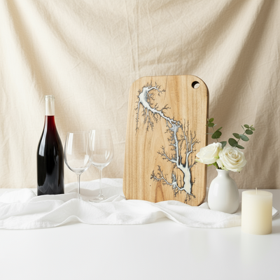 Wooden cutting board with tree design on a table with wine and flowers